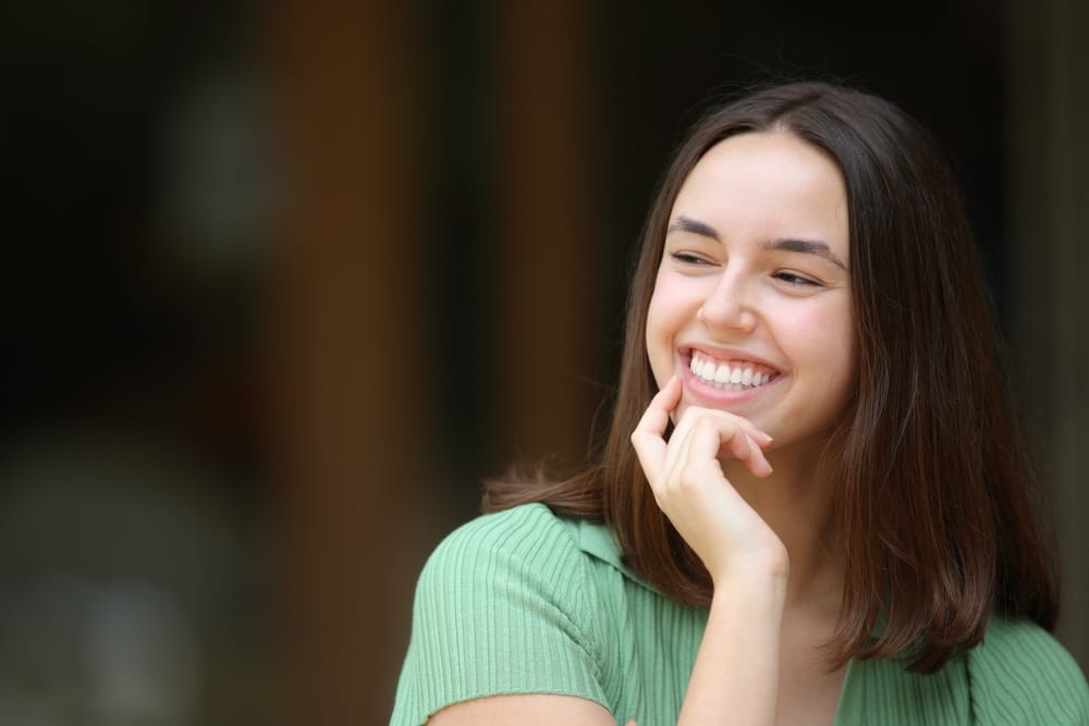 Happy woman smiling with perfect teeth in the street looks at side - Teeth Whitening Oro Valley AZ