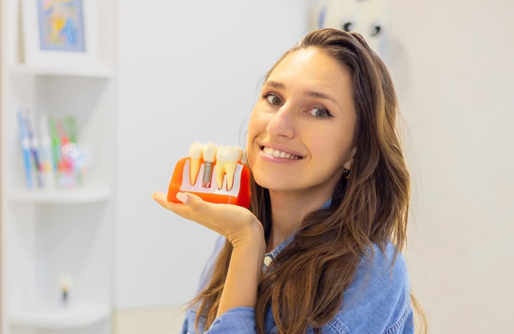 Woman holding a teeth model - Tooth Implant Tucson AZ