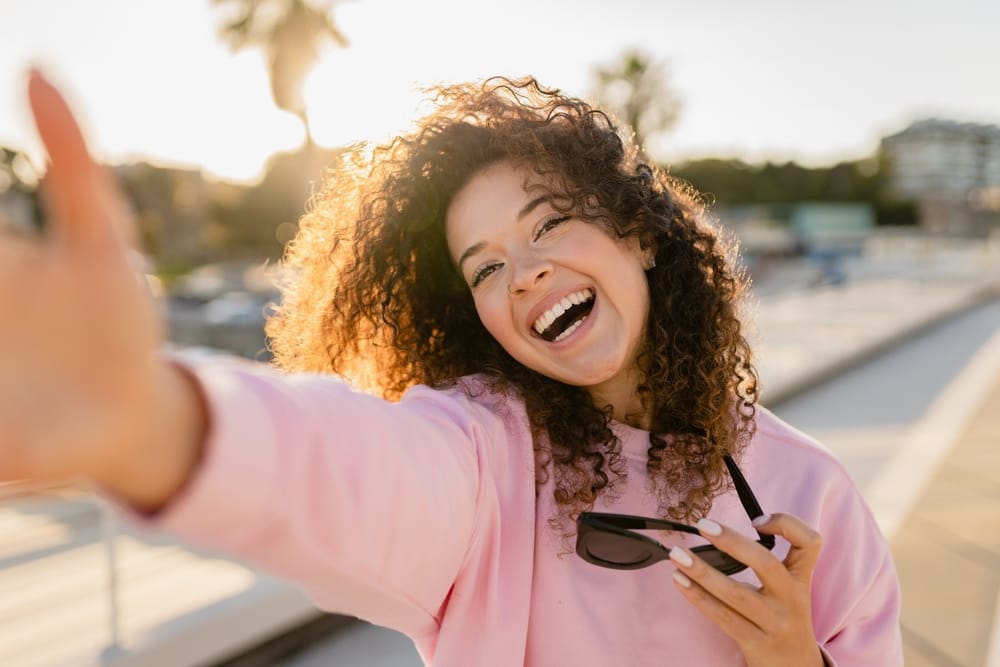 Woman with great teeth smiling outdoors - Teeth Whitening Tucson AZ